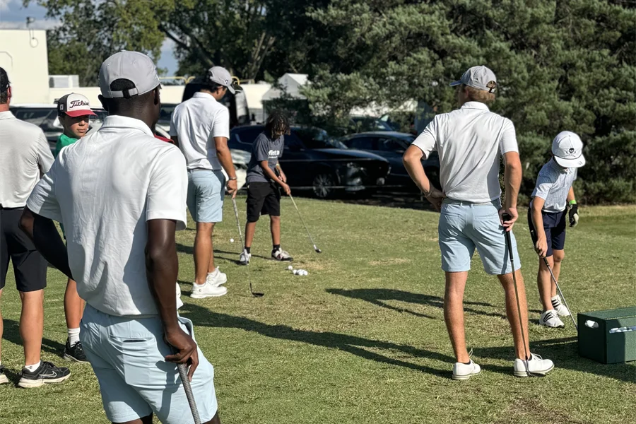 Young camper learning to swing at golf camp